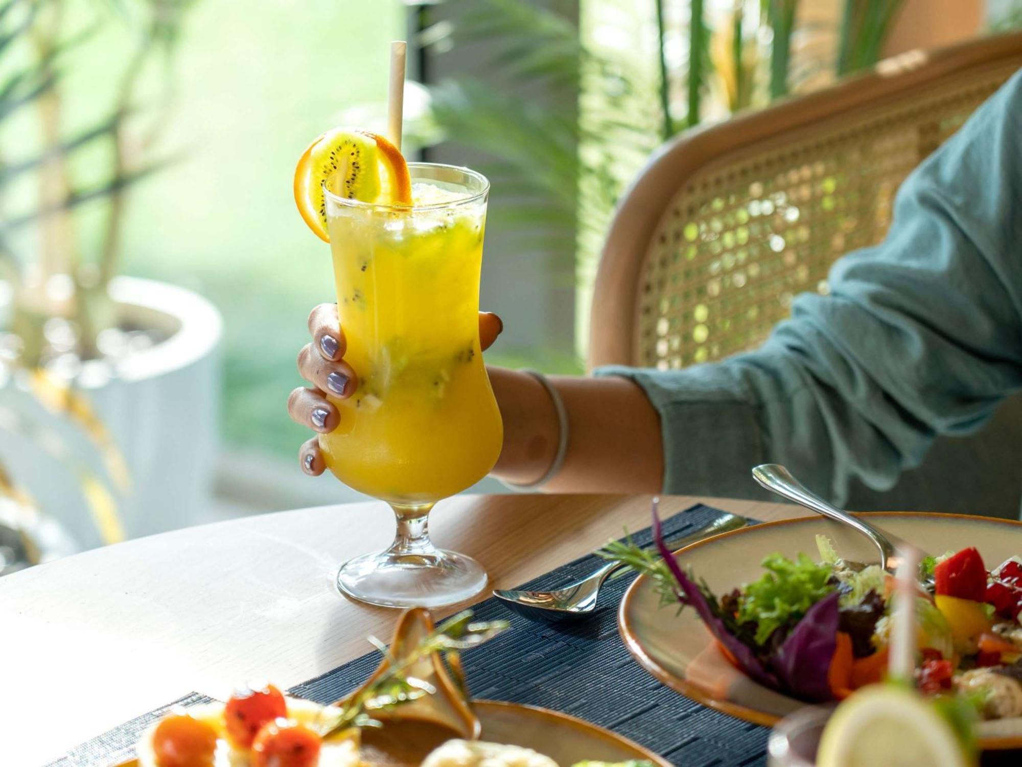 Swissotel Living 제다 외부 사진 A woman holding a glass of juice